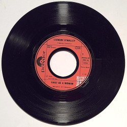 O’Malley Leonore : First be a woman / Put a rainbow in your heart - begagnad singelskiva